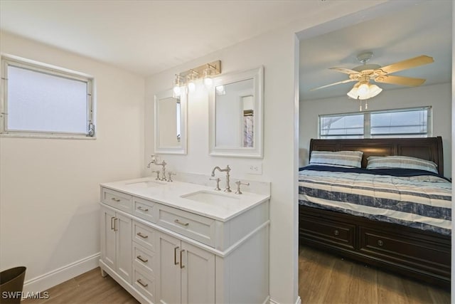 full bath featuring a sink, connected bathroom, wood finished floors, and double vanity