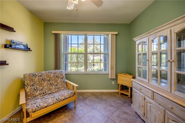 sitting room with dark tile patterned flooring, ceiling fan, and baseboards