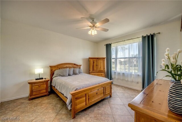 bedroom featuring light tile patterned floors, ceiling fan, and baseboards