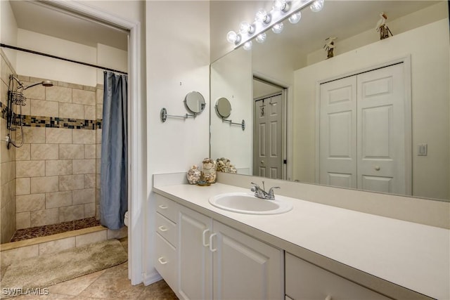 full bath with a tile shower, a closet, and vanity