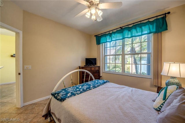 bedroom featuring baseboards, a ceiling fan, and tile patterned floors