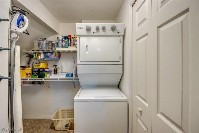 laundry room featuring laundry area, stacked washing maching and dryer, and tile patterned floors