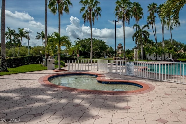 community pool featuring a patio and fence