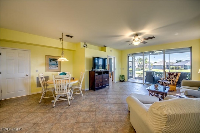 living area with a ceiling fan, visible vents, baseboards, and tile patterned floors