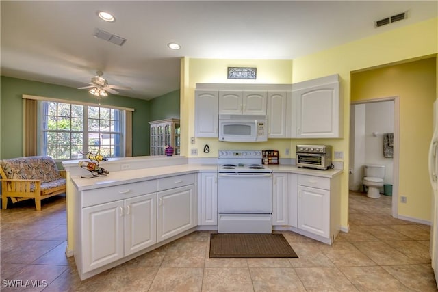 kitchen with light countertops, white appliances, visible vents, and white cabinetry