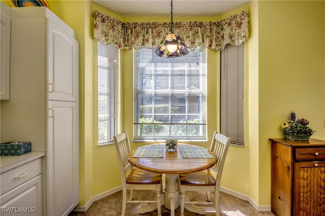 dining space featuring light tile patterned floors, plenty of natural light, and baseboards