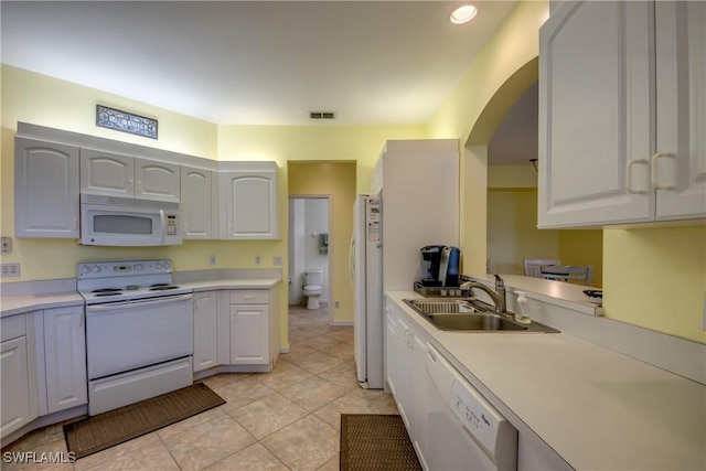 9321 Alamander Ct Unit 204, Fort Myers, FL 33919 - kitchen featuring white appliances, arched walkways, light countertops, and light tile patterned floors
