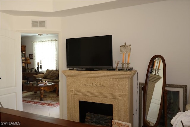 living room featuring visible vents, a fireplace, and tile patterned floors