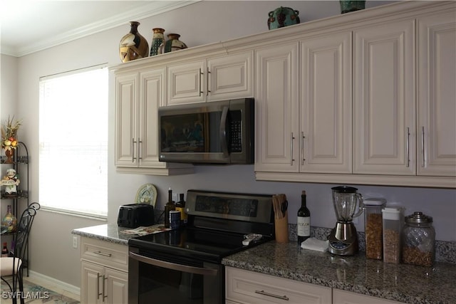 kitchen featuring appliances with stainless steel finishes, cream cabinets, stone countertops, and crown molding