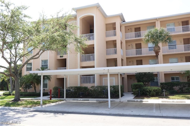 view of property with covered and uncovered parking