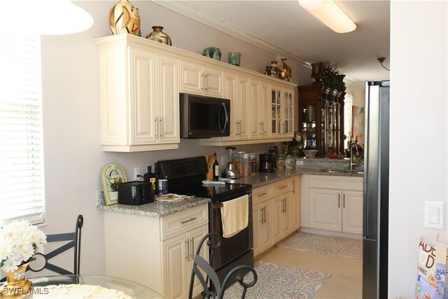 kitchen featuring glass insert cabinets, freestanding refrigerator, crown molding, black range with electric cooktop, and a sink