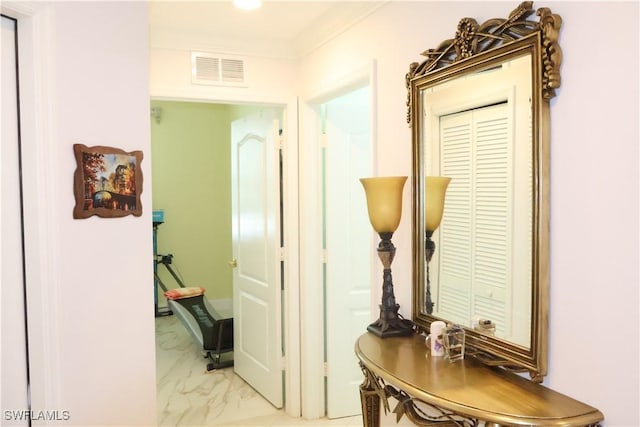 hall featuring ornamental molding, marble finish floor, and visible vents