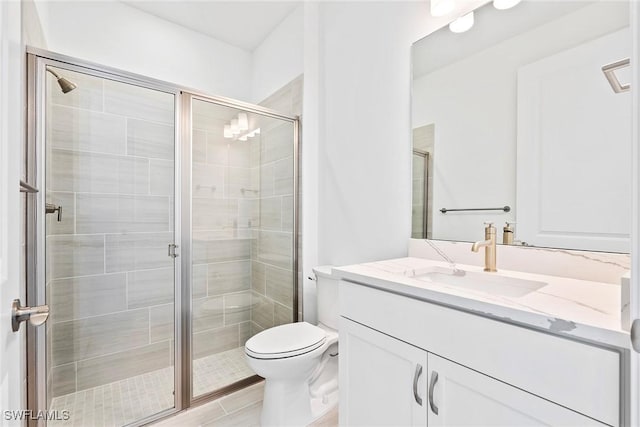 bathroom with vanity, a shower stall, and toilet