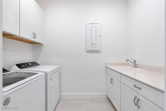 laundry area with cabinet space, baseboards, washer and clothes dryer, and a sink