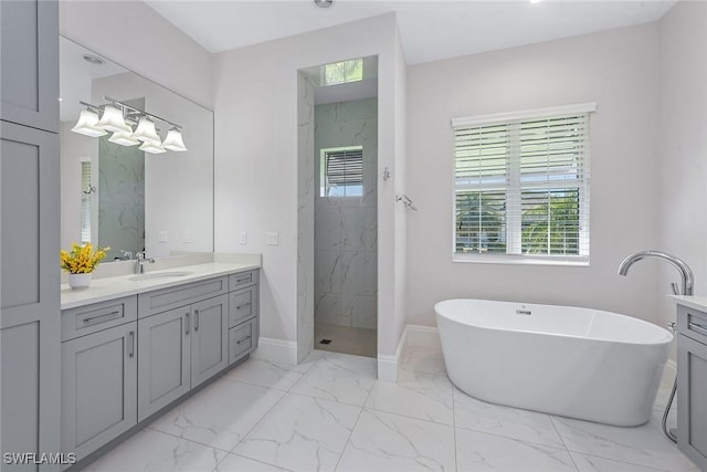 bathroom with a marble finish shower, baseboards, a freestanding tub, marble finish floor, and vanity