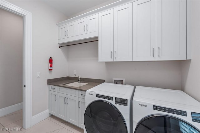 laundry area with baseboards, cabinet space, separate washer and dryer, a sink, and marble finish floor