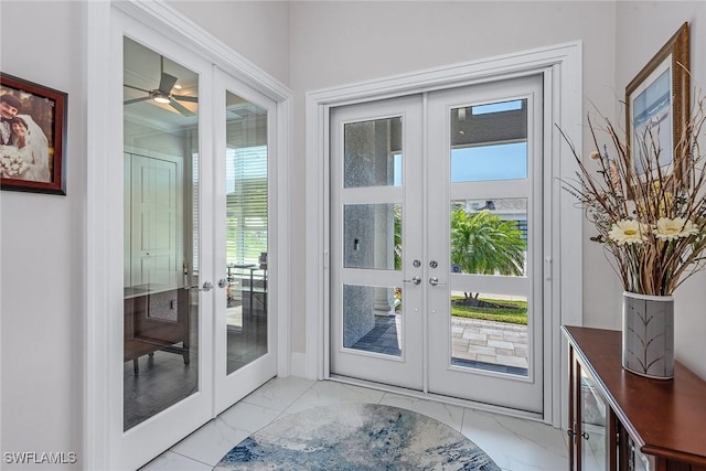 doorway to outside with french doors, plenty of natural light, and marble finish floor