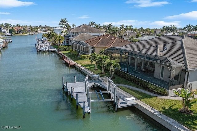 dock area with glass enclosure, a water view, a residential view, and boat lift