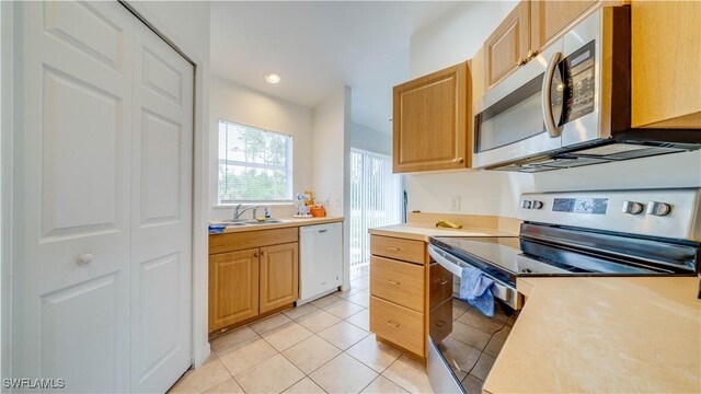 kitchen featuring light countertops, light tile patterned floors, recessed lighting, stainless steel appliances, and a sink