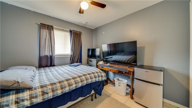 bedroom with light tile patterned floors, baseboards, freestanding refrigerator, and a ceiling fan