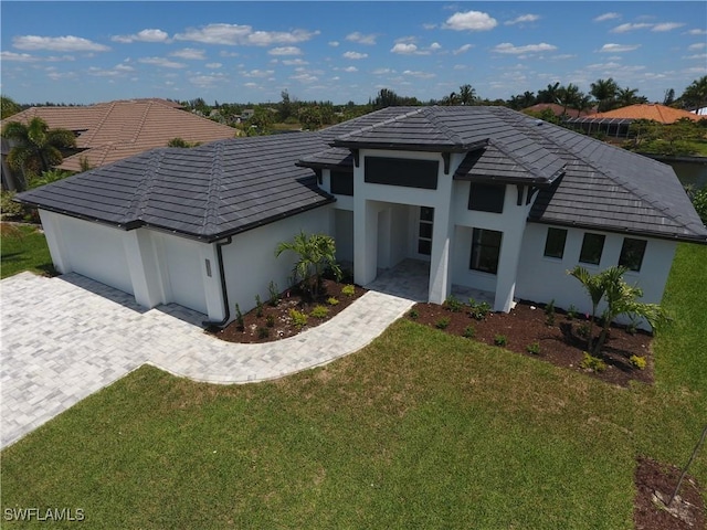 1523 NW 34th Ave, Cape Coral, FL 33993 - prairie-style home featuring stucco siding, a front yard, a tiled roof, and decorative driveway