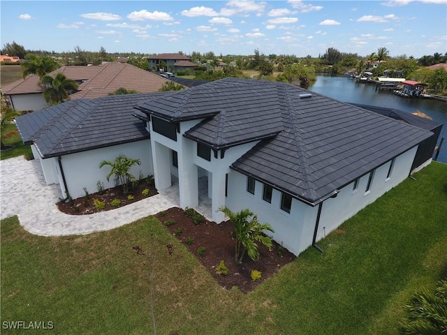 1523 NW 34th Ave, Cape Coral, FL 33993 - view of front facade with a front yard, stucco siding, and a water view