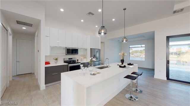 1523 NW 34th Ave, Cape Coral, FL 33993 - kitchen with appliances with stainless steel finishes, modern cabinets, white cabinetry, light countertops, and a breakfast bar area