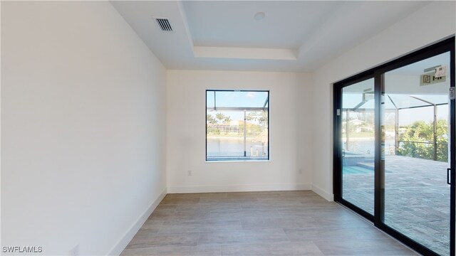 1523 NW 34th Ave, Cape Coral, FL 33993 - unfurnished room with a raised ceiling and light wood-style flooring