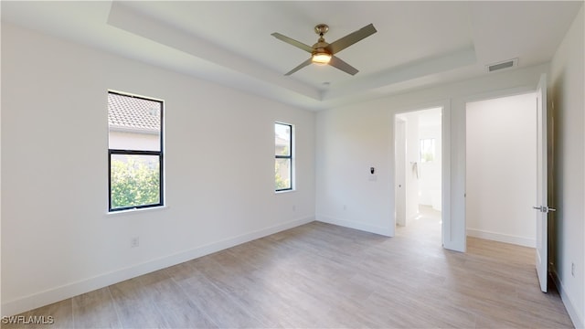 1523 NW 34th Ave, Cape Coral, FL 33993 - empty room featuring a raised ceiling, a ceiling fan, and light wood-style flooring