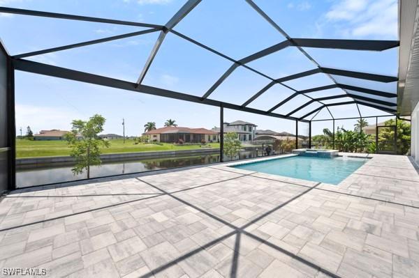 1523 NW 34th Ave, Cape Coral, FL 33993 - view of swimming pool featuring a patio, a pool with connected hot tub, a water view, and a lanai