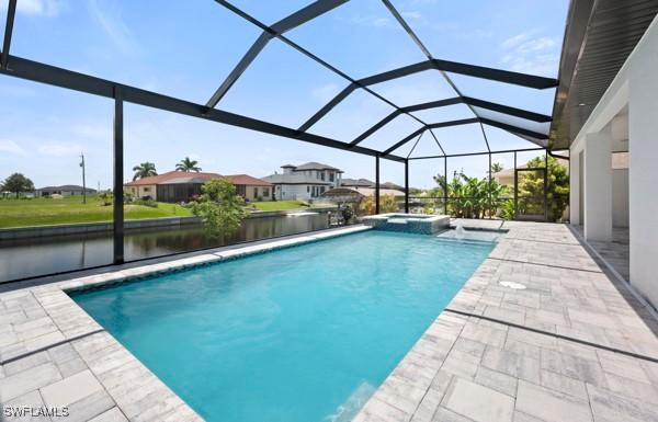 1523 NW 34th Ave, Cape Coral, FL 33993 - view of swimming pool with a pool with connected hot tub, a patio, a lanai, and a water view