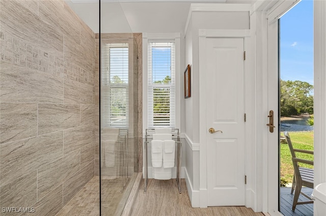 bathroom with wood finished floors, a freestanding tub, and walk in shower