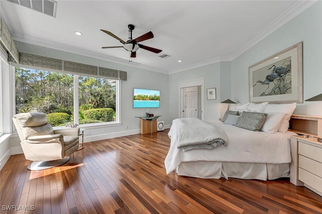 bedroom featuring visible vents, baseboards, crown molding, and wood finished floors