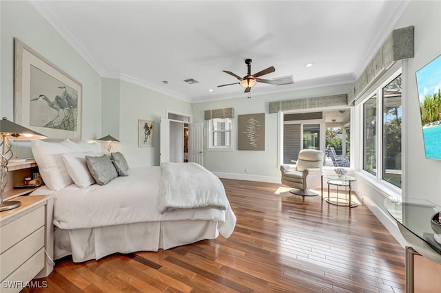 bedroom with ornamental molding, visible vents, baseboards, and wood finished floors