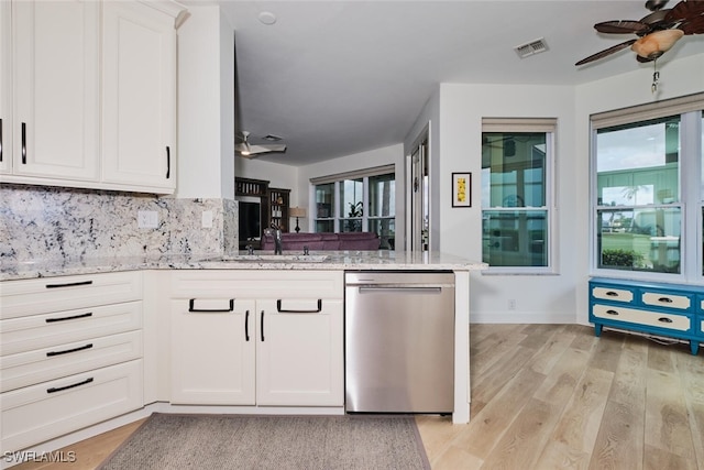 kitchen featuring dishwasher, ceiling fan, visible vents, and light stone countertops