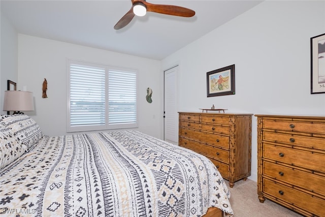 bedroom with light carpet and a ceiling fan