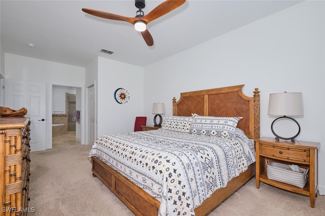 bedroom with a closet, light colored carpet, visible vents, ensuite bathroom, and a ceiling fan