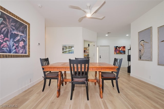 dining area featuring baseboards, a ceiling fan, and light wood-style floors