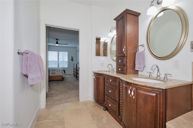 bathroom with ensuite bathroom, double vanity, a sink, and baseboards