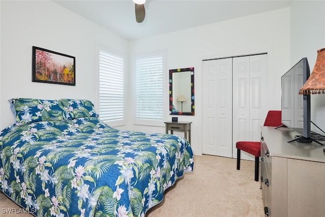 bedroom with a closet, light colored carpet, and ceiling fan