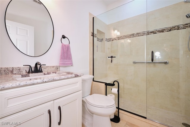 full bathroom with toilet, a stall shower, and vanity