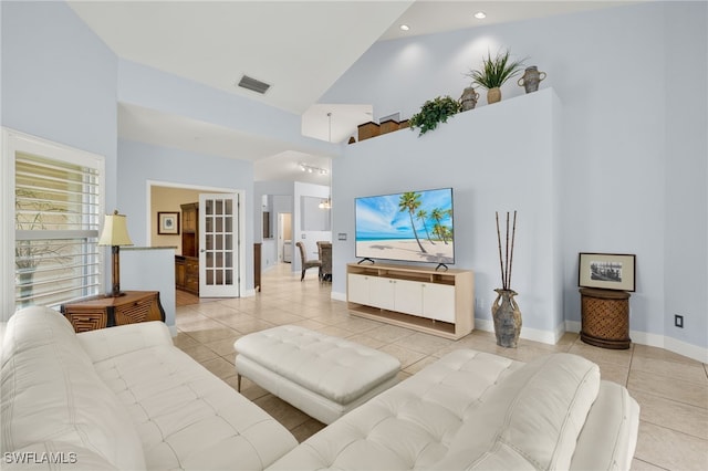 living room featuring visible vents, a high ceiling, and light tile patterned floors