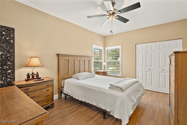 bedroom with light wood-style floors, baseboards, a ceiling fan, and a closet