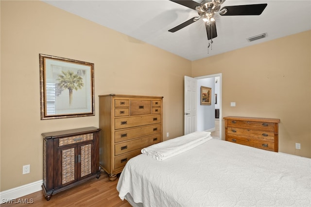 bedroom with visible vents, ceiling fan, baseboards, and wood finished floors