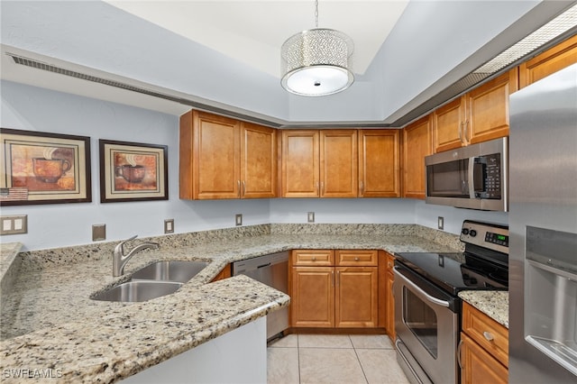 kitchen featuring brown cabinetry, stainless steel appliances, and a sink