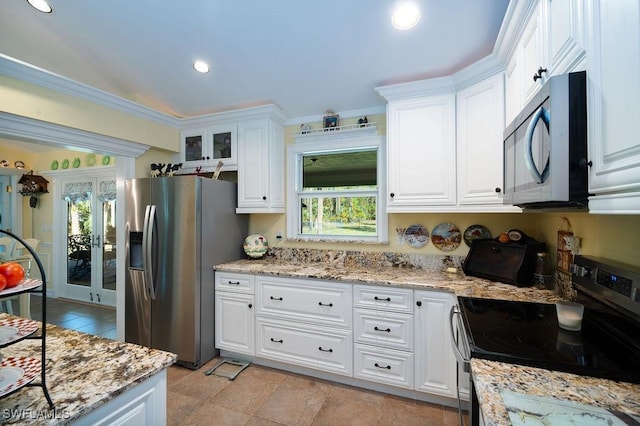 kitchen with white cabinets, light stone counters, and stainless steel appliances