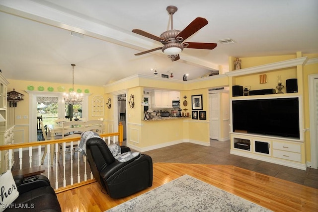 living room featuring lofted ceiling with beams, visible vents, wood finished floors, and ceiling fan with notable chandelier