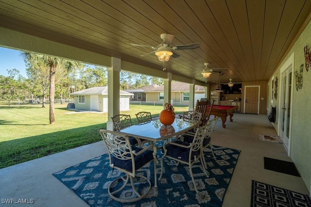 view of patio / terrace featuring outdoor dining area, an outdoor structure, fence, and a ceiling fan