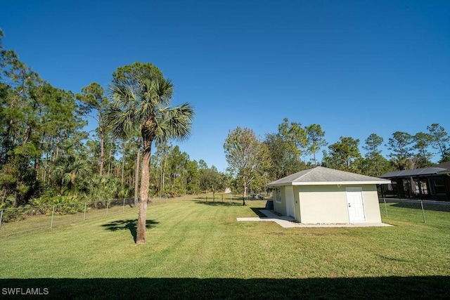 view of yard with a storage shed, a fenced backyard, and an outbuilding