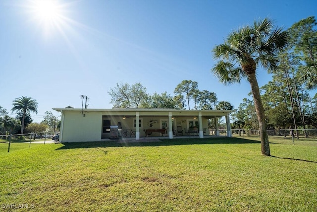 rear view of property with a patio area, a lawn, and fence